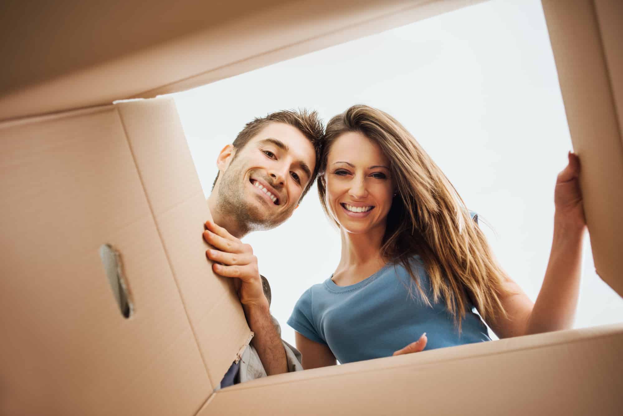 Zwei Personen schauen in ein geöffnetes Paket hinein.