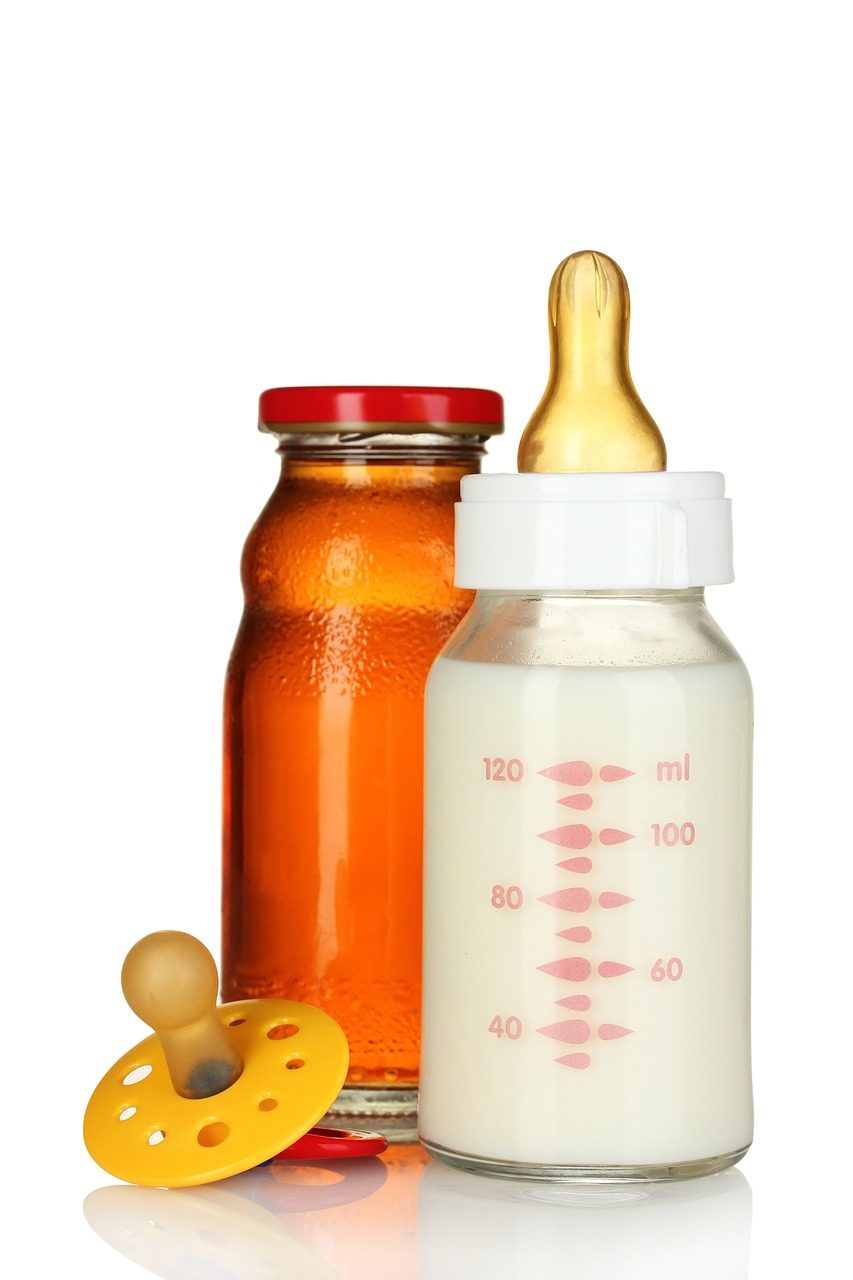 Babyflasche mit Milch, Saftflasche und gelber Schnuller