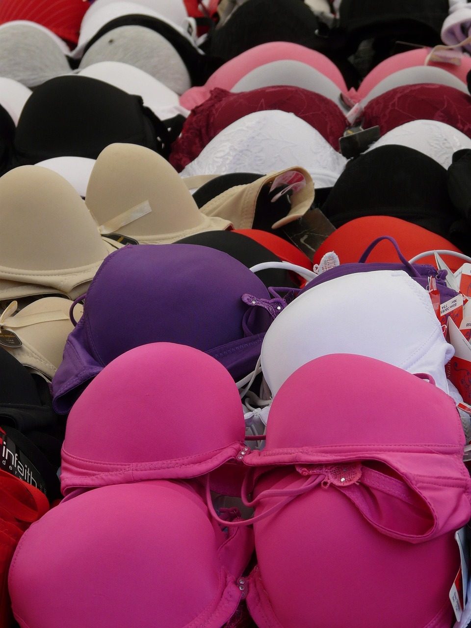 Viele BHs in Rosa, Schwarz, Weiß und Lila dicht nebeneinander