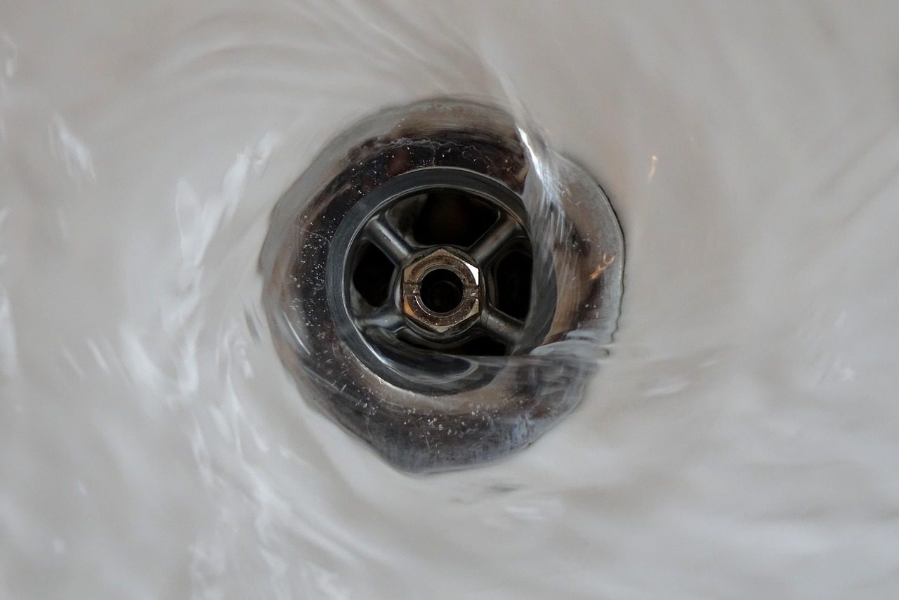 Wasser strudelt in einen verchromten Abfluss