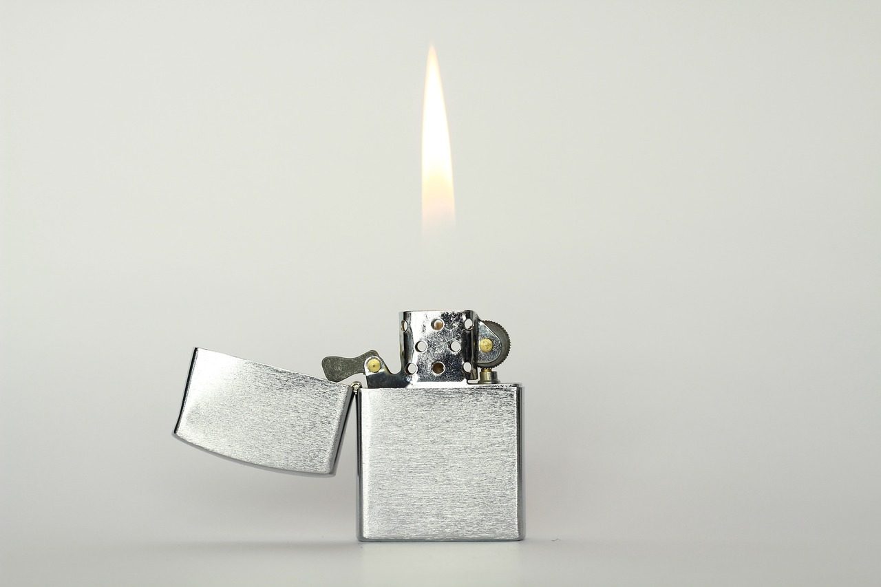 Aufgeklapptes Sturmfeuerzeug aus Metall mit Flamme
