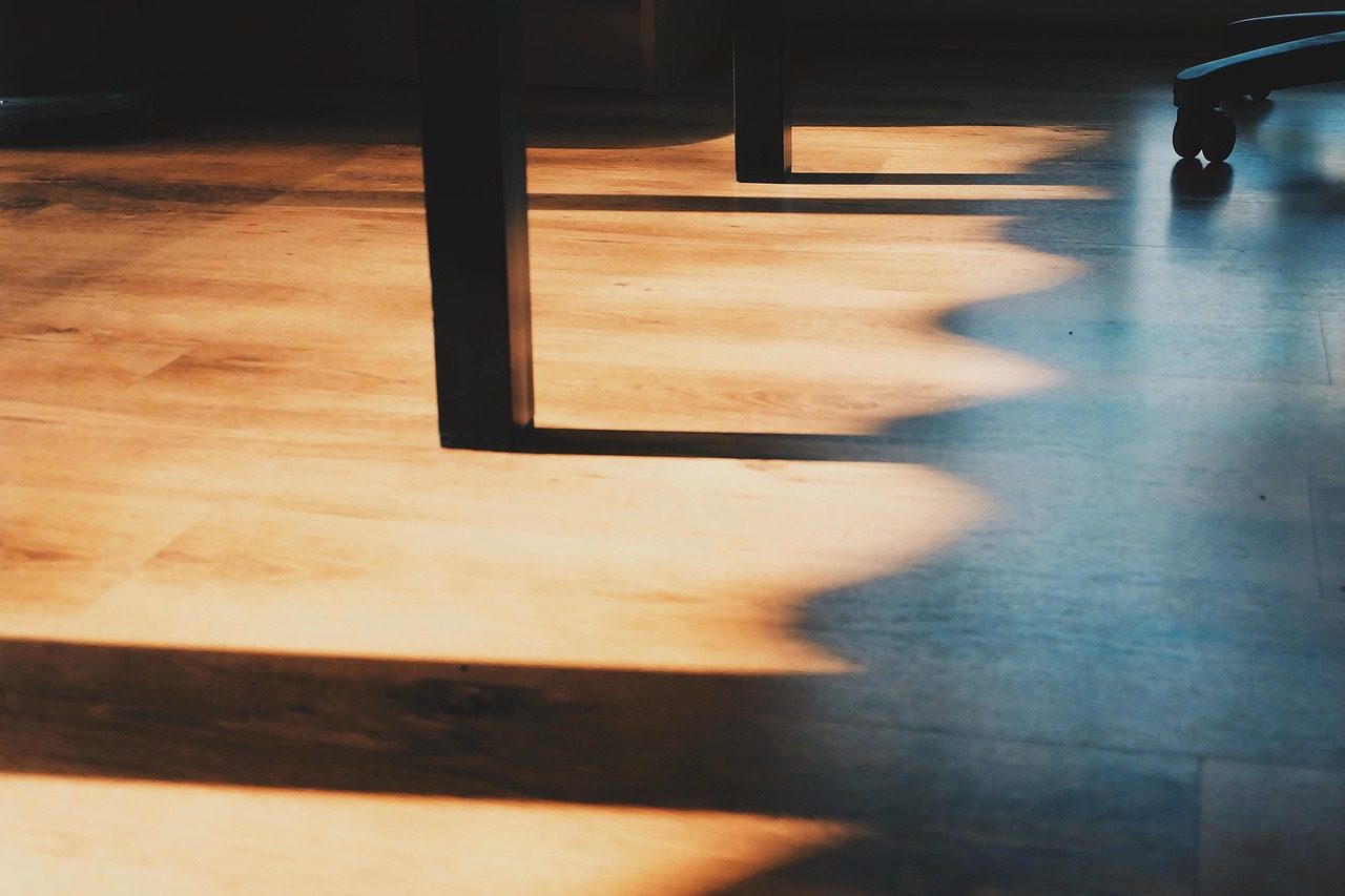 Stuhlbeine auf einem Holzboden im Gegenlicht