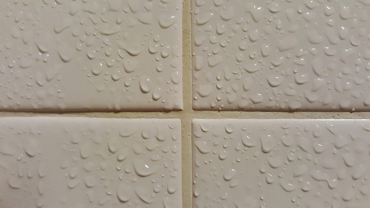 Helle Wandfliesen mit Fugen und Wassertropfen