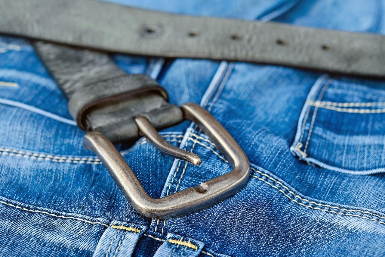 Blaue Jeans mit Ledergürtel und Metallschnalle in Nahaufnahme