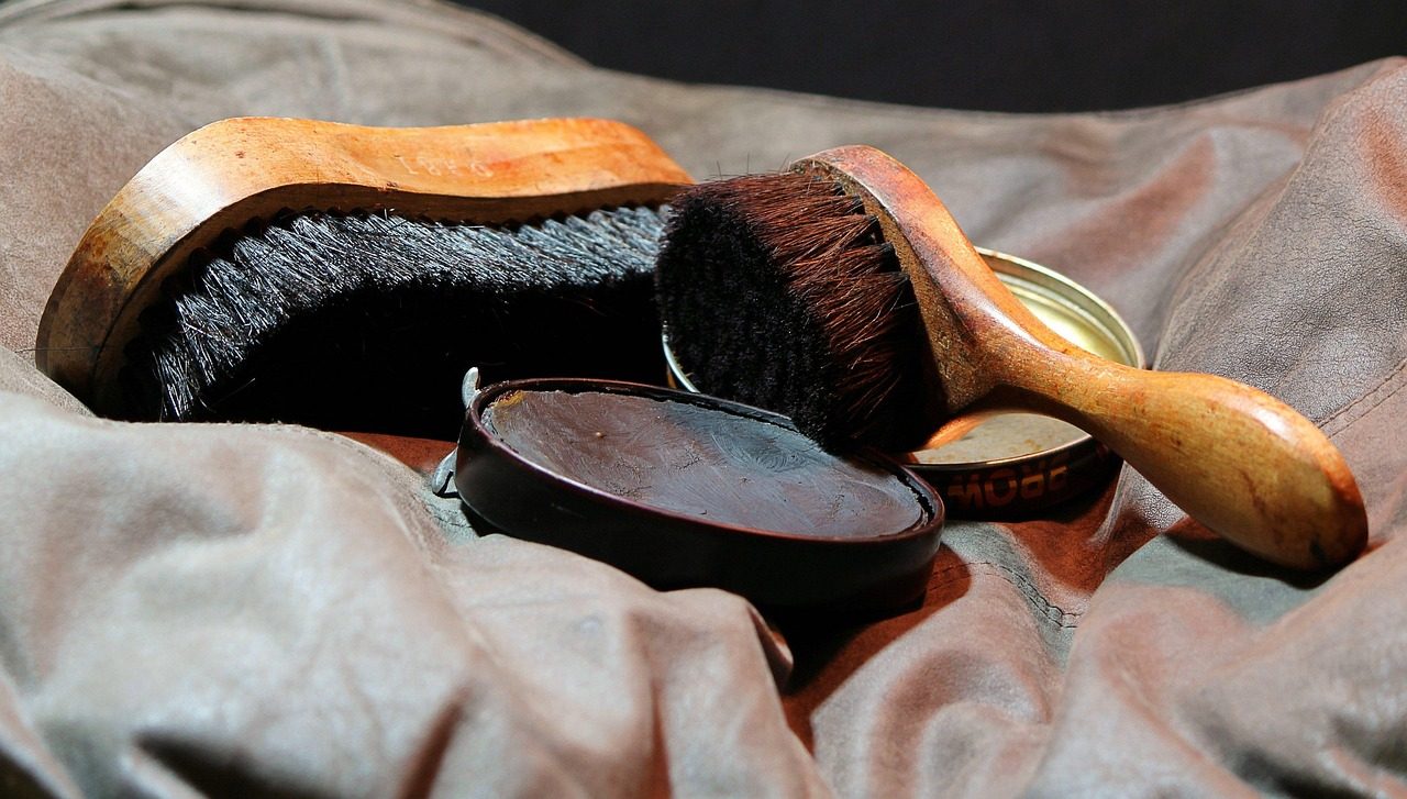 Schuhbürsten und eine offene Dose Schuhcreme auf einem Tuch