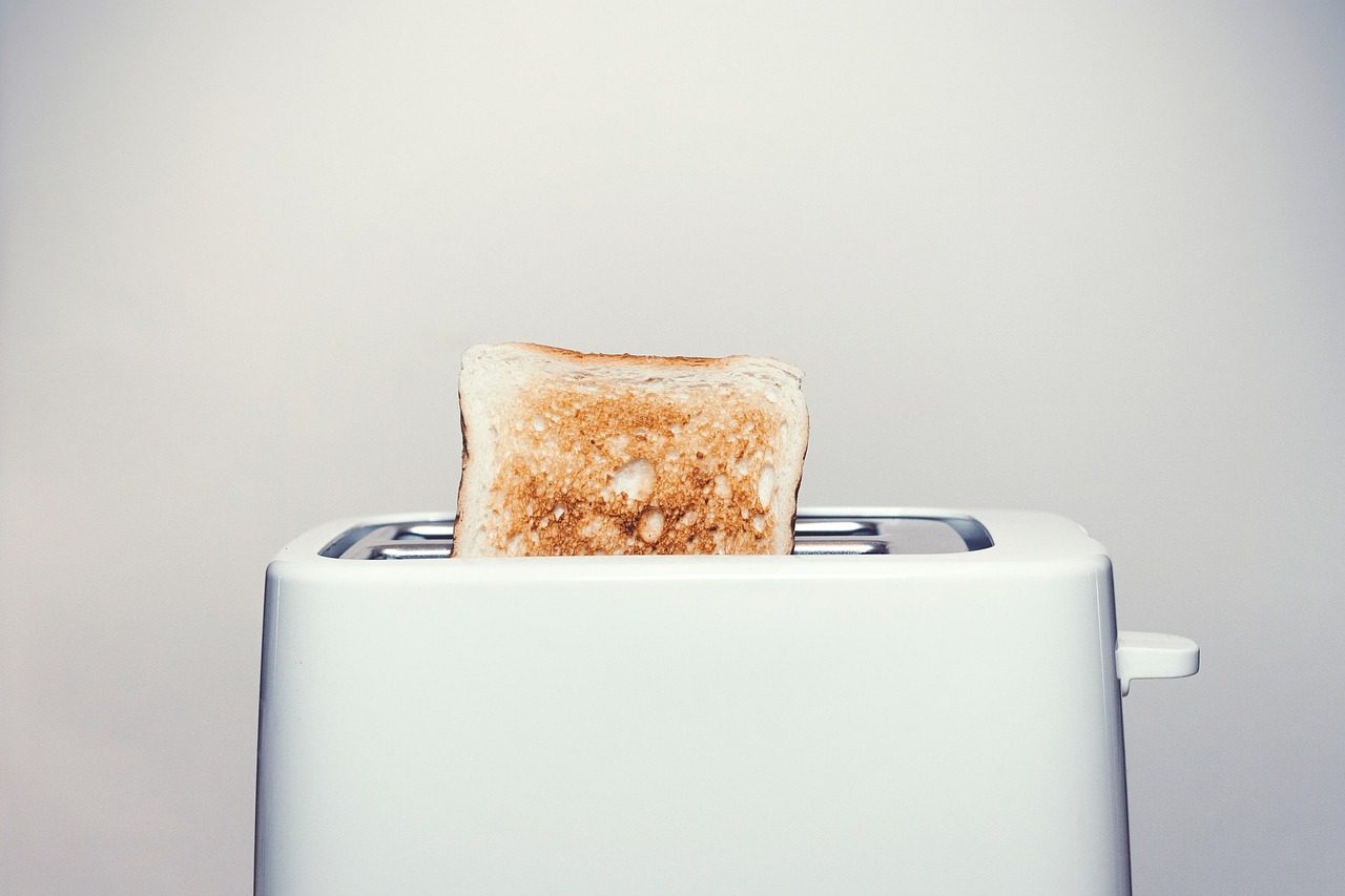 Weißer Toaster mit herausragender Brotscheibe