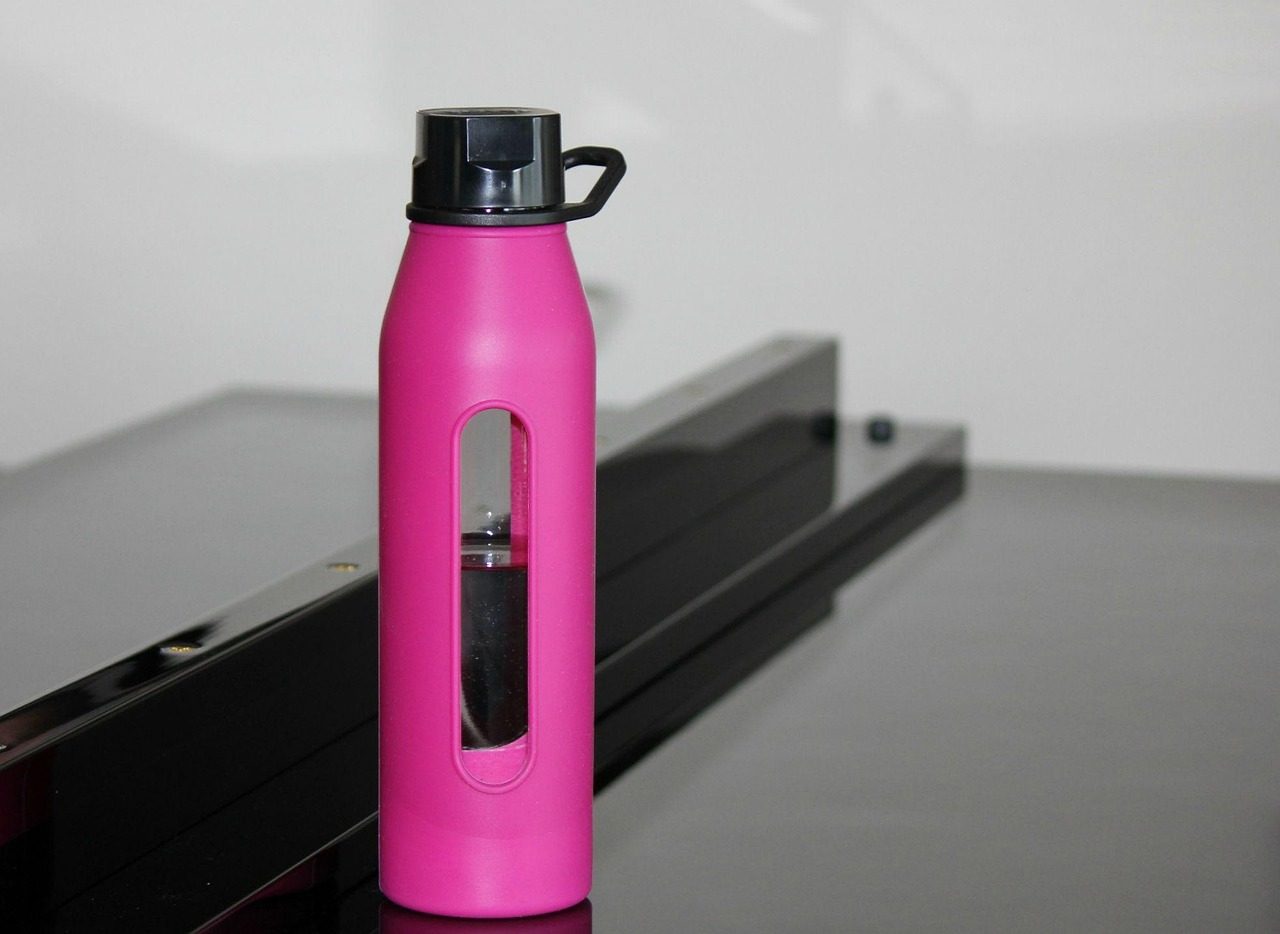 Pinke Glastrinkflasche mit Silikonhülle und schwarzem Schraubdeckel